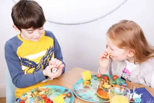 Playte Together - Girl and boy eating and playing on the "Playte Together" game plates